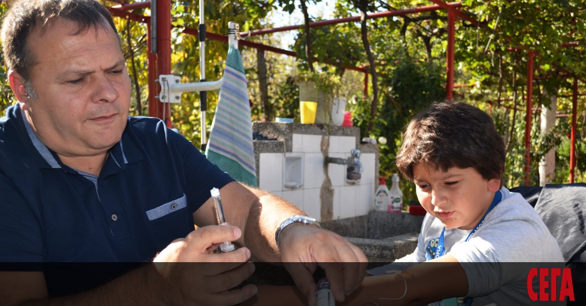 Двама родители повиват след къпане четиримесечното си бебе. До него