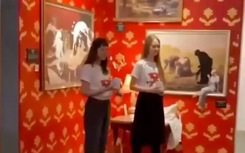 Активистките пред залятата с крем творба.