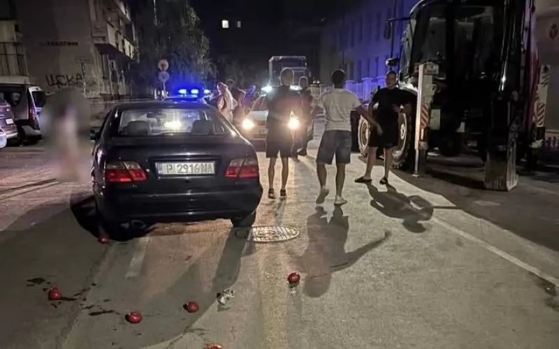 Снимка от мястото на инцидента с полицейския шеф Николай Кожухаров в Русе, разпространена от "Бърд". Вижда се колата на младежите, две полицейски  патрулки и няколко от действащите лица. Тримата младежи очевидно не са в отлична бойна форма и ако умеят да се бият са в категория "Муха". Четвъртият снима. Полицаите говорят с Кожухаров, жена му и съседа му. Жената на Кожухаров преди това е хвърляла домати, които явно е носела със себе си. Детето (което сме заличили) гледа отстрани.