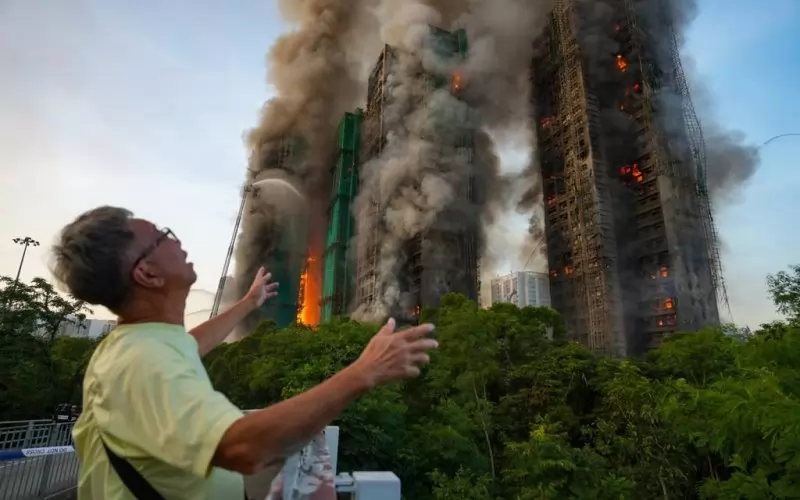 Минувач съпреживява трагедията при вида на горящата сграда в Хонконг.