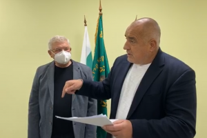 С няколко бели листа в ръка с новината за потвърдения