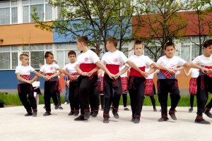 Деца свирещи на музикални инструменти и потропващи народни хора от