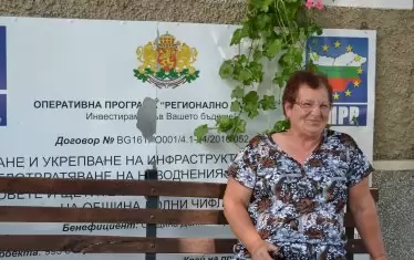  Баба Венетка Димитрова говори с усмивка, поседнала на пейка пред стара и вече ненужна тебела, информираща за европейски проект.