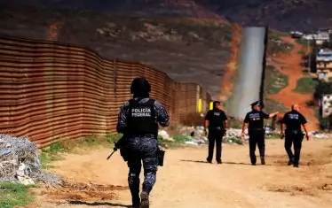 Мексикански граничари пазят стената край Тихуана.