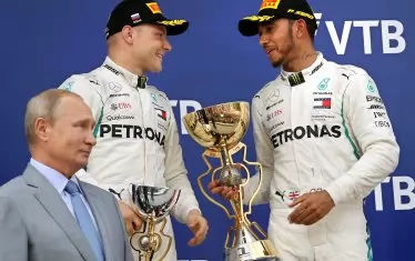 Хамилтън (вдясно) и Ботас си говорят, след като Владимир Путин им е връчил купите в Сочи.