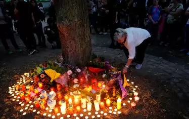  Граждани палят свещи край мястото на трагедията в Кьотен. 
