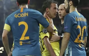 Капитанът на "Атлетико" Диего Годин (№2) е хванал за гушата Марио Гьотце от "Борусия" (Дортмунд), за да го възпре от по-нататъшна конфронтация с Хуанфран по време на мача между двата тима, спечелен с 4:0 от германския тим.