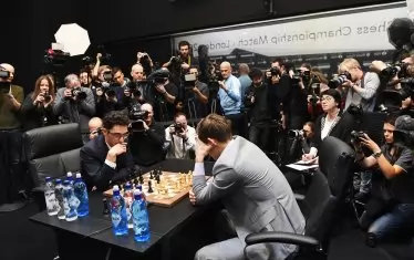 Десетки репортери, оператори и фотографи са обградили масата, за да увековечат старта на решаващите битки между Магнус Карлсен и Фабиано Каруана в партиите на рапид.