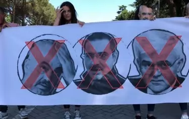  През октомври вътрешният министър Фатмир Джафай (на плаката вдясно) подаде оставка след масови протести - неговият брат (снимката на плаката в центъра) бил замесен в наркобизнеса. Отляво е ликът на премиера Еди Рама. 