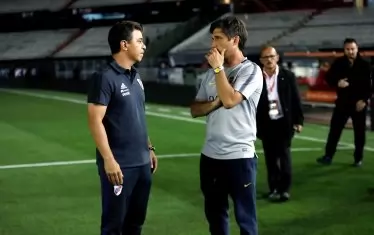 Треньорът на "Ривър Плейт" Марсело Гаярдо (вляво) говори с колегата си от "Бока Хуниорс" Густаво Барос Скелото след отлагането на мача.