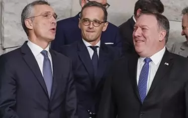  Генералният секретар на НАТО Йенс Столтенберг (вляво) разговаря с американския държавен секретар Майк Помпео (вдясно) пред погледа на германския външен министър Хайко Маас, на последната среща на алианса през декември в Брюксел. 