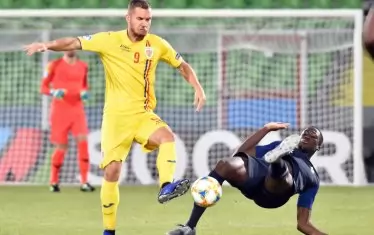 Румънецът Георге Пушкаш е атакуван от френския защитник Ибрахима Конате (вдясно) в ръководения от българския рефер мач в Реджо Емилия.