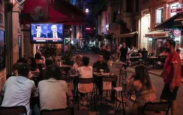  Хора гледат телевизионния дебат в едно от кафенетата в Истанбул. 