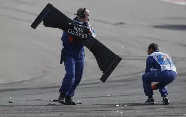 Маршалите на трасето в Остин, Тексас, изнасят задното крило на "Заубер"-а на Адриан Сутил след катастрофата му по време на "Гран при" на САЩ през 2014 г.