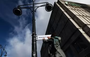 Жена закача табела на централна улица в Берлин с името на Маргарете Пьолман по време на Международния ден на жените - 8 март. Пьолман е първата жена, допусната да произнесе реч в парламента на Прусия през 1919.