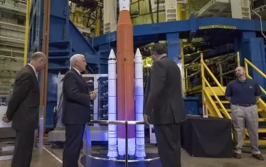 Американският вицепрезидент Майк Пенс разглежда в НАСА макет на ракетата SLS - версията от ХХ век на лунната ракета „Сатурн 5“ от мисията „Аполо“. 
