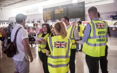 Служители на британското посолство в Испания дават информация на клиент на "Томас Кук" на летището в Лансароте, Канарски острови.