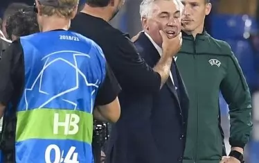 Мениджърът на "Ливърпул" Юрген Клоп (с шапката) щипва дружелюбно по бузите треньора на "Наполи" Карло Анчелоти след края на мача в Неапол.