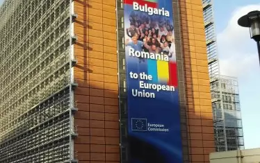  На 1 януари 2007 г. Европейската комисия приветства с голям плакат върху сградата си в Брюксел приемането на България и Румъния. Оттогава те бяха в тандем под наблюдение заради проблеми с върховенството на закона. Сега за първи път ЕК прави опит да ги раздели, като възнамерява да спре наблюдението за България и да го продължи за Румъния.