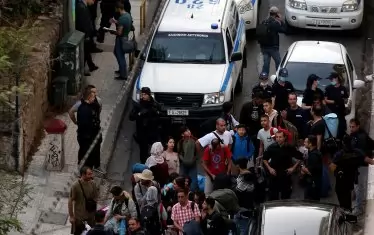 Гръцката полиция извежда семейства имигранти от жилища в атинския квартал Екзархия, за да ги премести в бежански лагери.