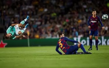 Защитникът на "Барселона" Жерар Пике (на земята) е вдигнал във въздуха с острото си влизане халфа на "Интер" Никола Барела по време на мача от група F на ст. "Камп Ноу".