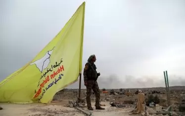   Боец от Сирийските сили за сигурност (СДС) охранява жълтия флаг на организацията върху покрива на сграда в с.Багуз. На 23 март 2019 г. подкрепяните от САЩ СДС обявиха победа над Ислямска държава след 4-годишна битка срещу ислямистката групировка в Сирия и Ирак.