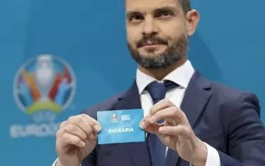 Бившият гръцки национал Ангелос Харистеас показва листчето с надпис "България" по време на тегленето в централата на УЕФА.