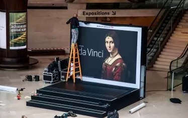 Служител на Лувъра монтира постер на "Прекрасната Ферониера" - един от шедьоврите, с които бе рекламирана изложбата.