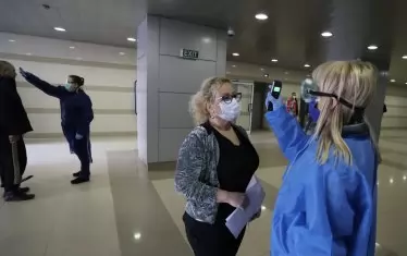 Доброволци и служители на ВМА мерят температурата на всеки посетител в сградата на болницата. 

