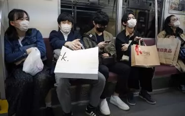Японци с маски пътуват в метрото в Токио. Губернаторът Койке поиска хората да останат вкъщи през уикенда нафона на рязко увеличение на броя на коронавирусните инфекции Covid-19 в Токио. Досега около 300 души са били тествани положително на коронавирус Covid-19 в японската столица.