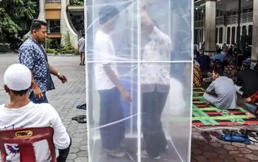 Мюсюлмани минават през дезинфекционна камера, създадена с цел да предотврати разпространението на коронавирус, преди да влязат за молитва в джамия в Медан, Северна Суматра, Индонезия. Индонезийските власти призовават гражданите да избягват публични събирания, включително религиозни дейности като предпазна мярка срещу разпространението на коронавирус. В Индонезия има 1047 потвърдени случая на коронавирус,  87 души са починали

