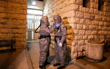 Ултраортодоксални евреи от еврейската погребална организация Кадиша (Хевра кадишах) със защитни костюми се подготвят да носят тленните останки на 72-годишния равин Масуд Хаму от Франция, починал от Ковид-19, в погребален дом в Йерусалим, Израел. В Израел има заразени 2666 души и 8 починали 