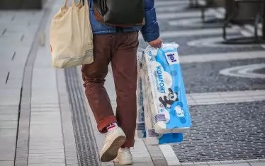  Мъж в Мюнхен се връща от магазин, след като се е презапасил с тоалетна хартия. Необяснимата мания в резултат на епидемията за изкупуване на тоалетна хартия завладя и германците.