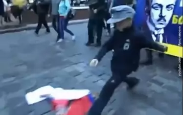  Малко украинско фашистче подритва руското знаме. 