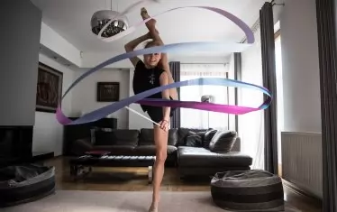  Полската състезателка по художествена гимнастика опитва да поддържа форма в хола си.