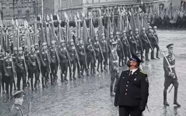 Военен оглежда постер с архивен кадър от Парада на победата на 24 юни 1945 г.