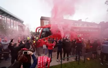 На фона на празните трибуни, пред "Анфийлд" се бяха събрали десетки хиляди фенове, за да направят своя празник. Те посрещнаха с възторжени възгласи и запалиха факли при пристигането на автобуса с футболистите.