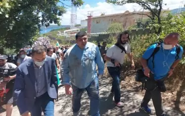 Кметът Николов (с маската) води народа на плаж. До него Иво Мирчев със следи от борба по себе си. 