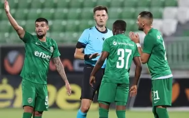 Украинският рефер Денис Шурман е наобиколен от част от футболистите на "Лудогорец", които се опитват да го убедят да отсъди дузпа.