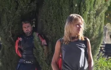 урски троянец и руска туристка.
Пред магазина, в очакване някой да поиска да се снима с него, се прозяваше един скучаещ „троянец“ с разпасан вид и карирани 3/4 панталони, подаващи се под поличката. Но при появата на няколко по-привлекателни туристки троянецът се оживи и се постегна. 