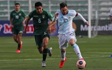 Боливиецът Диего Ваяр (вляво) преследва капитана на Аржентина Лионел Меси по време на двубоя в Ла Пас.