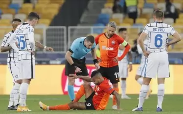 Българският съдия Георги Кабаков проверява състоянието на бразилския нападател на "Шахтьор" Дентиньо пред отегчените погледи на играчите на "Интер".