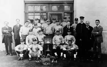 Диркетор Люис Е. Лоус (вторият от ляво на дясно) с бейзболния отбор на затвора.