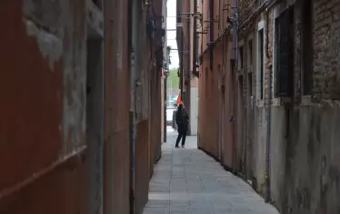 Тясната уличка изглежда пуста и тиха, но невидими очи и уши дебнат зад дантелените завески. 