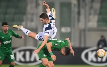 Бен Дейвис се е качил върху гърба на Клаудиу Кешерю при борба за топката в средата на терена.