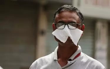 Мъж се опитва да се предпази със салфетка в началото на епидемията в Манама, Бахрейн. Сега малкото кралство се оказва световен лидер във ваксинациите. 