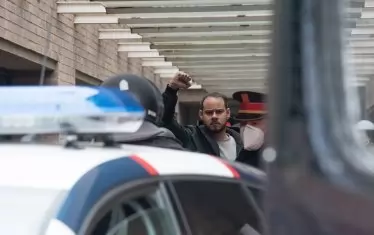 Полицията извежда рапъра.„Никога няма да ни накарат да отстъпим!“, зарича се той. 