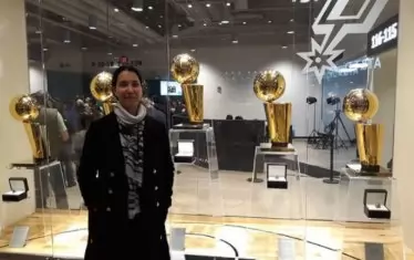 Австралийката позира пред шампионските купи на "Сан Антонио" по време на стажа си при "шпорите".