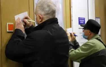 Възрастни хора попълват информирано съгласие в коридора на ваксинационен кабинет в София. 