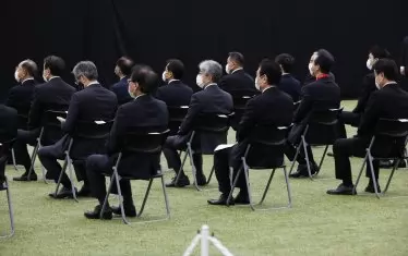 Малцината допуснати официални лица бяха разположени шахматно и носеха задължителните предпазни маски за лице.